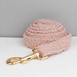 Pink textured dog leash with a gold clasp on a light gray background
