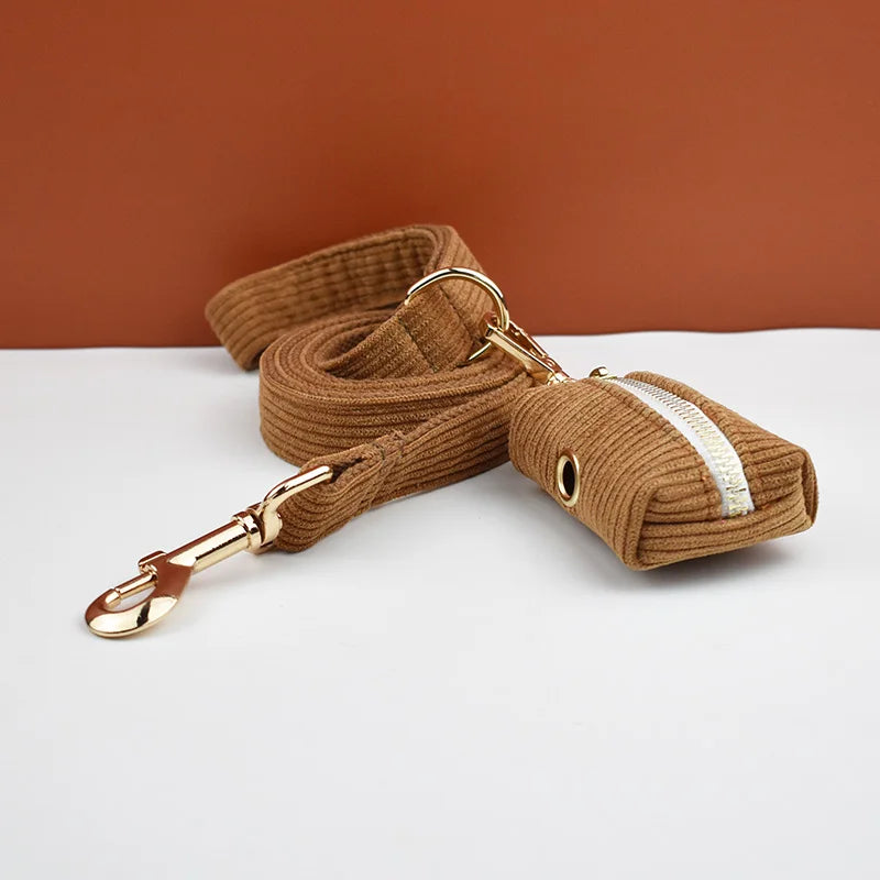 Brown dog leash with gold clip on a white surface against a brown background