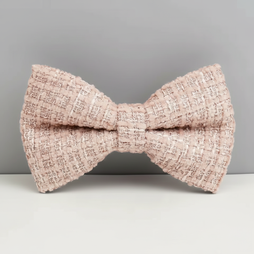 Pink textured bow tie on a gray background