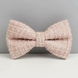 Pink textured bow tie on a gray background