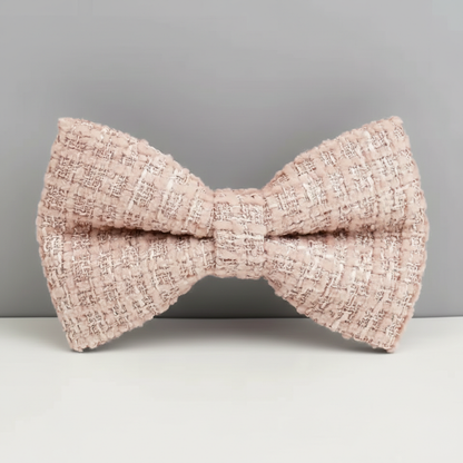 Pink textured bow tie on a gray background