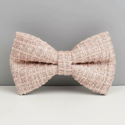 Pink textured bow tie on a gray background