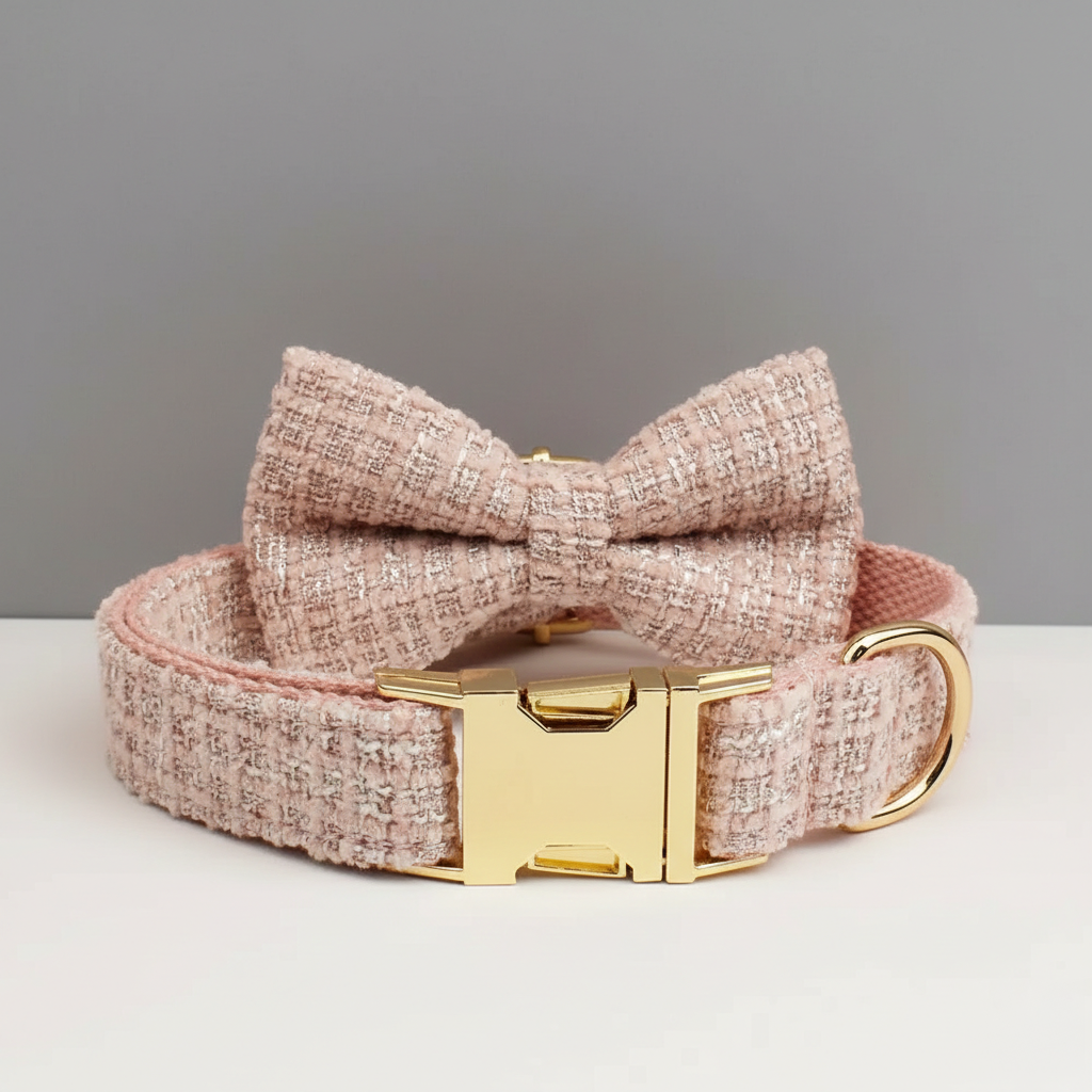 Pink textured dog collar with a bow and gold buckle on a light gray background