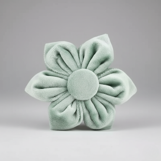 Light green fabric flower on a gray background