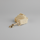 Beige dog leash with gold clasp on a gray background