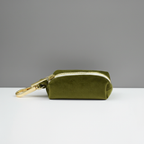 Green pouch with gold zipper and clasp on a white surface with gray background