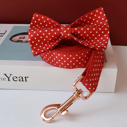 Red polka dot dog bow tie and leash with rose gold clip on a magazine