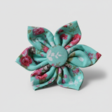 Floral fabric flower with a central button on a light gray background
