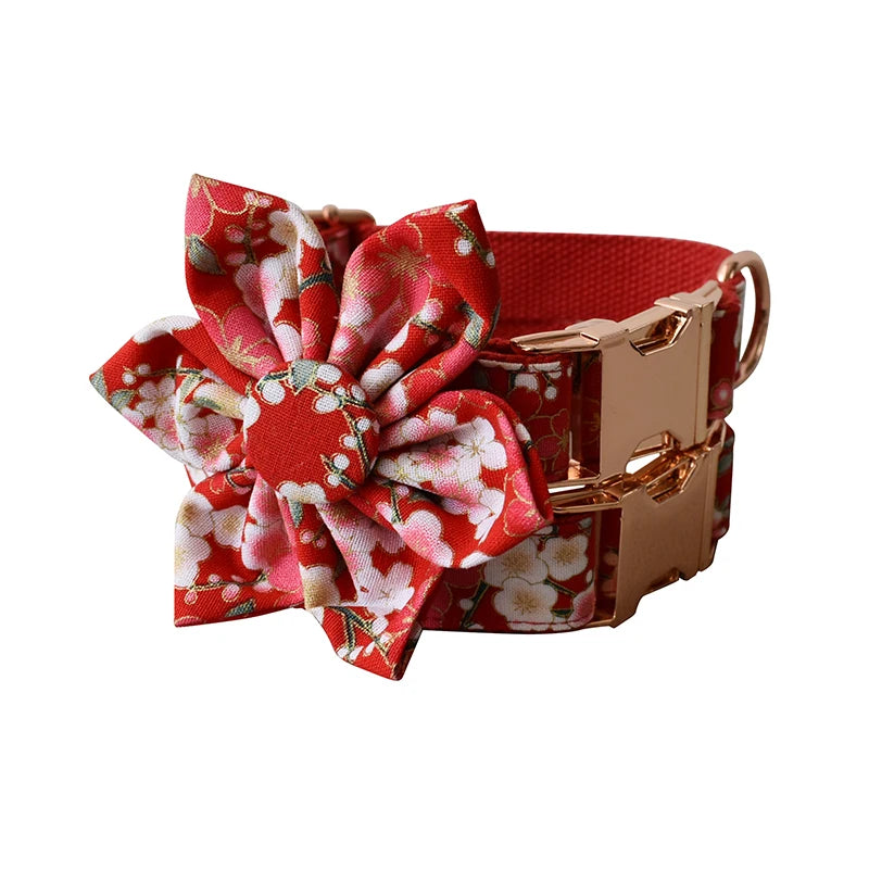 Red floral dog collar with a matching flower accessory on a white background