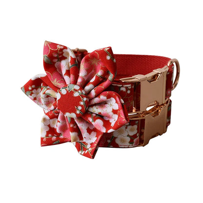 Red floral dog collar with a matching flower accessory on a white background