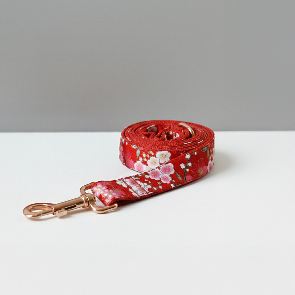 Red floral dog leash on a white surface with a gray background