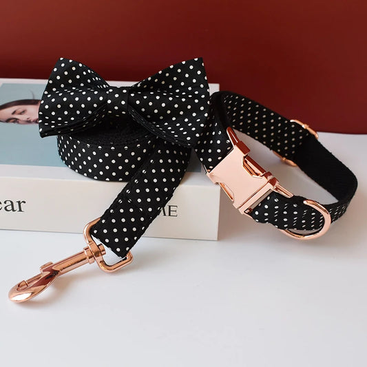 Black polka dot dog leash with rose gold hardware on a white surface