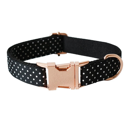 Black polka dot dog collar with a rose gold buckle on a white background