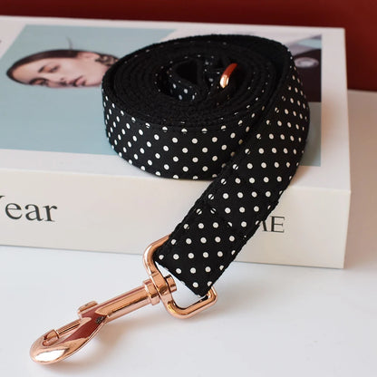 Black polka dot dog leash with rose gold clip on a magazine