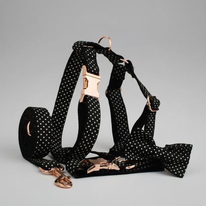 Black polka dot dog harness with rose gold hardware on a gray background