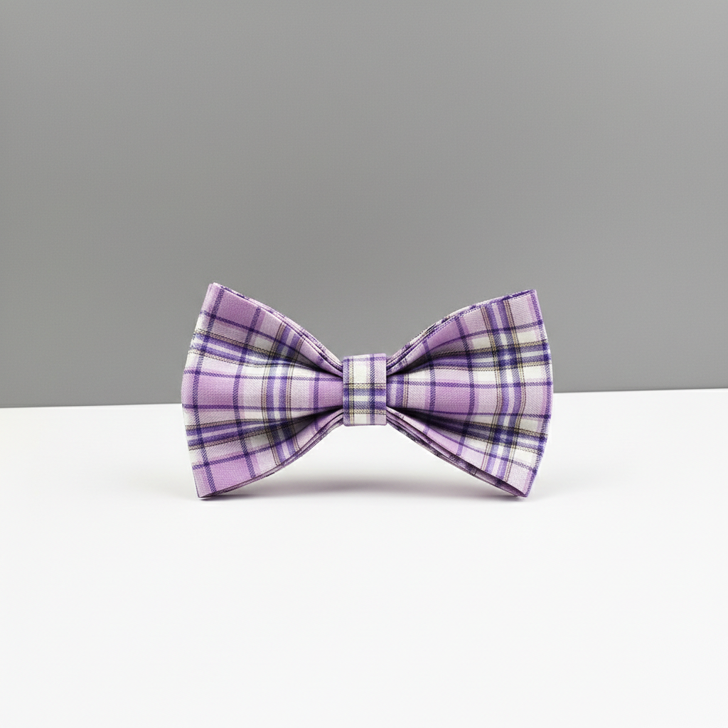 Purple plaid bow tie on a white surface with a gray background