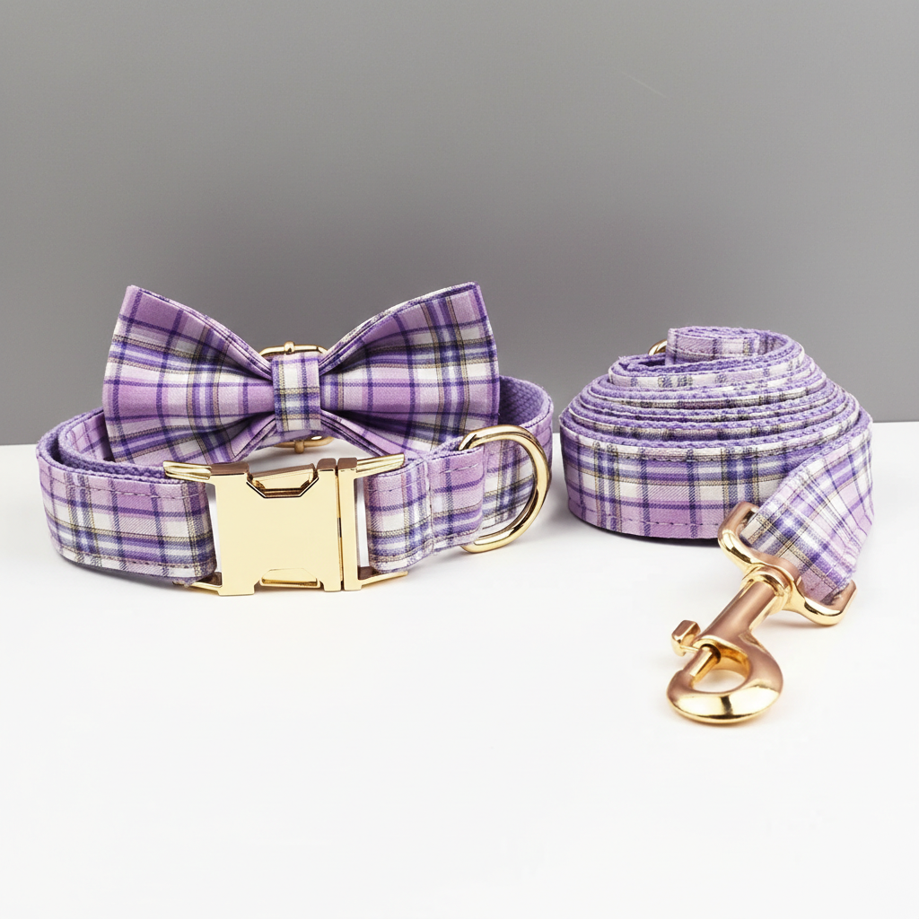 Purple plaid dog collar, leash, and bow tie set on a gray background