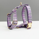 Purple plaid dog harness with gold hardware on a gray background
