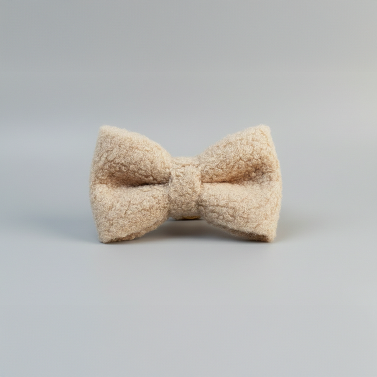 Beige bow tie on a gray background