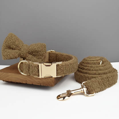 Brown dog collar with bow tie and matching leash on a gray background