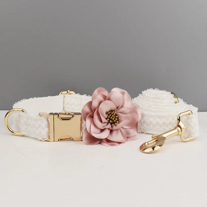 White textured dog collar with a pink floral accessory on a gray background