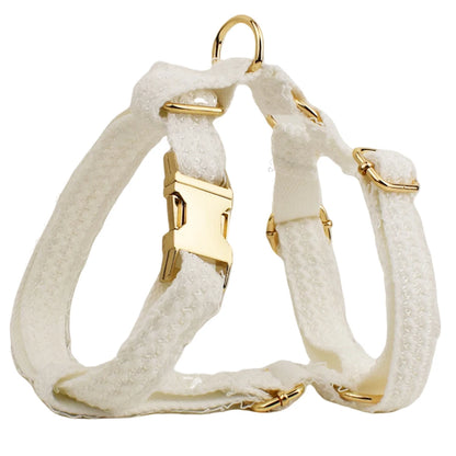 White dog harness with gold hardware on a white background