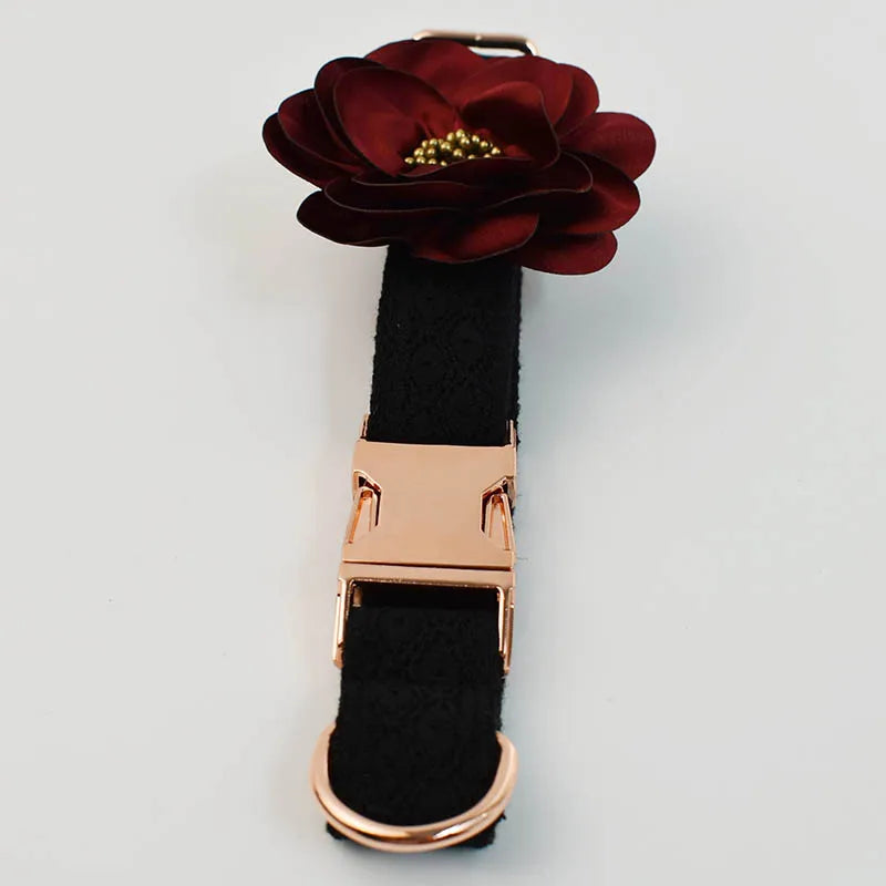 Black dog collar with a rose gold clasp and burgundy flower accessory on a light gray background