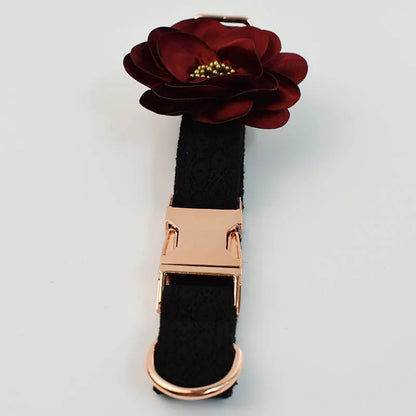 Black dog collar with a rose gold clasp and burgundy flower accessory on a light gray background