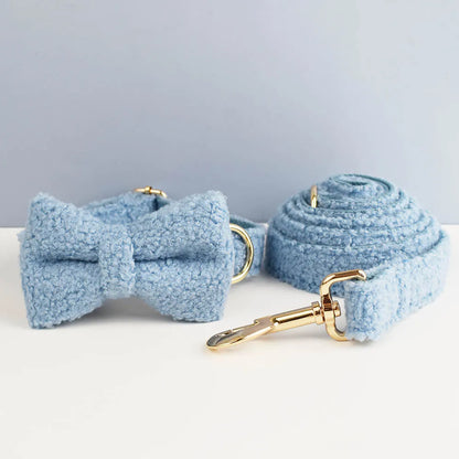 Light blue dog collar with bow tie and leash on a white surface