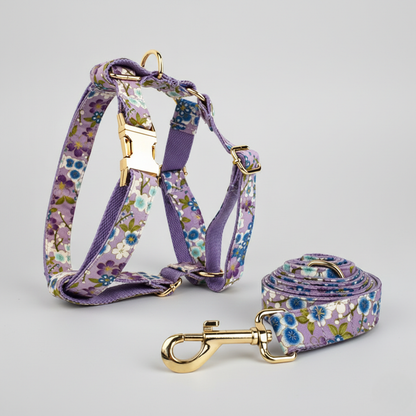 Floral-patterned dog harness and leash set with gold hardware on a light gray background