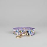Floral-patterned dog leash with a gold buckle on a gray background